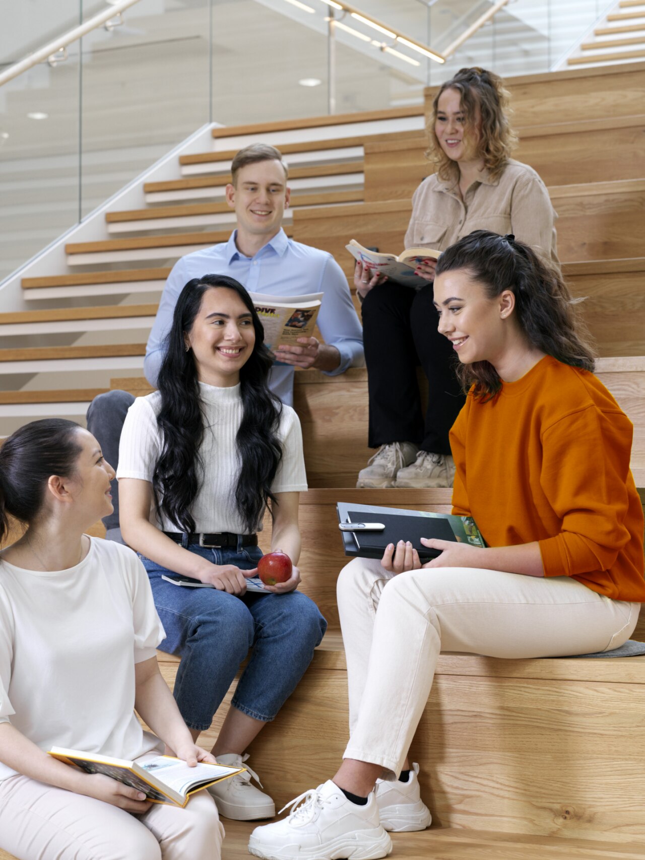 Small group of students sitting and talking. One of them has Roger On clipped to her notepad. Small group of students sitting and talking. One of them has Roger On clipped to her notepad.