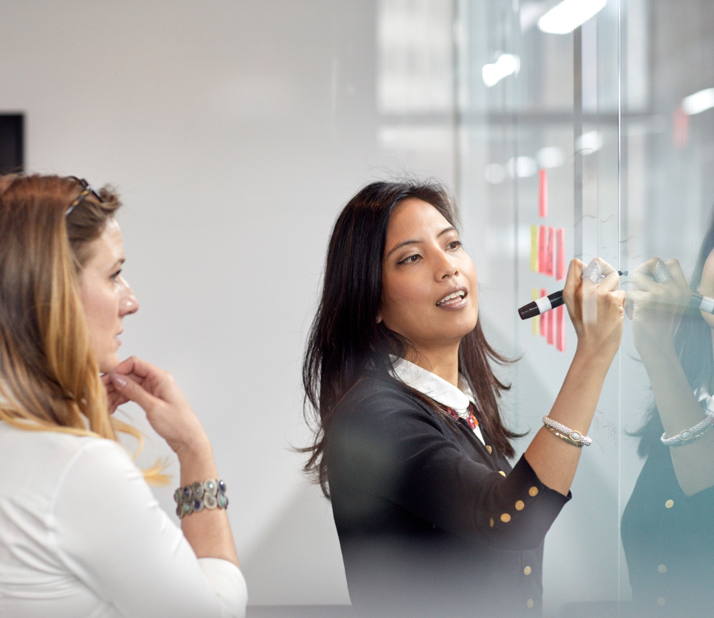 Businesswoman looking at female colleague presenting some ideas in the office.