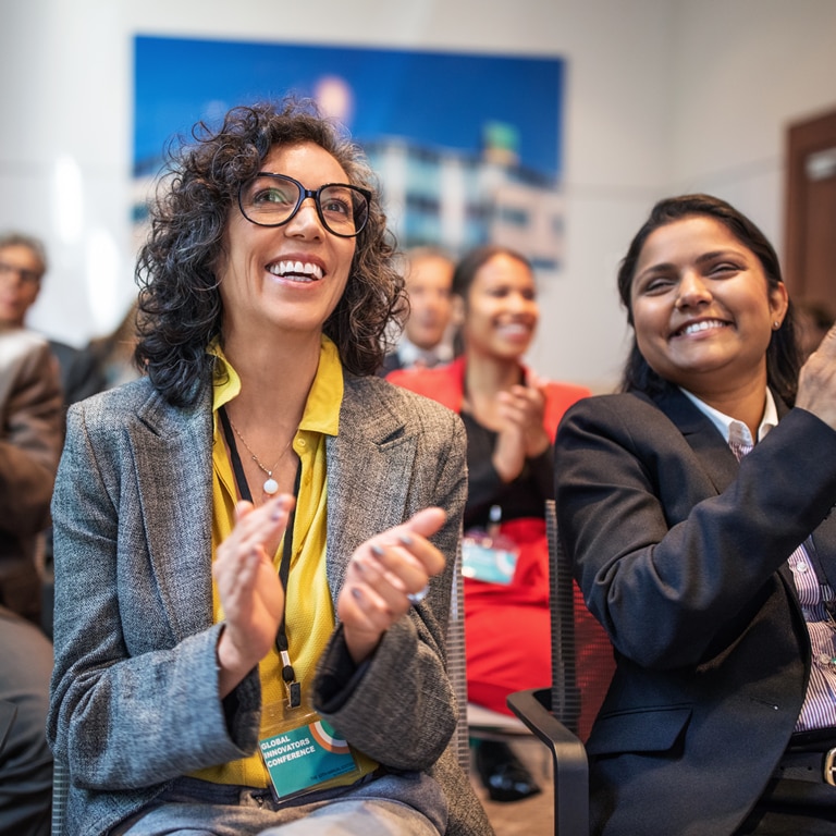 Hearing care professionals applauding at conference