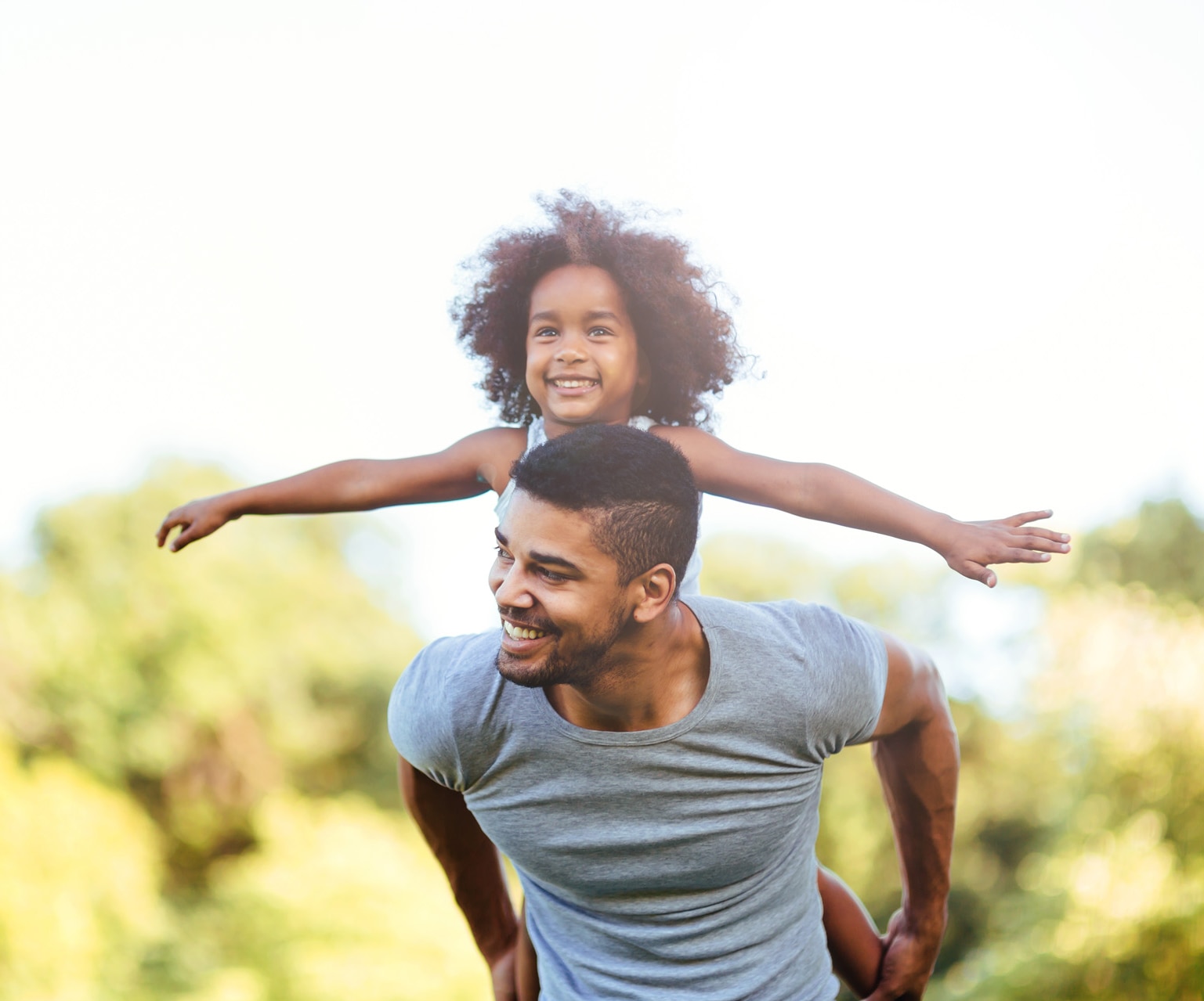 A young father carrying his daughter on his back