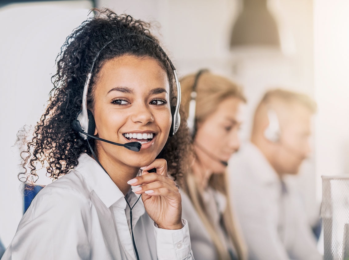 Hero image of a smiling young lady with headphones, a call center specialist helping customers