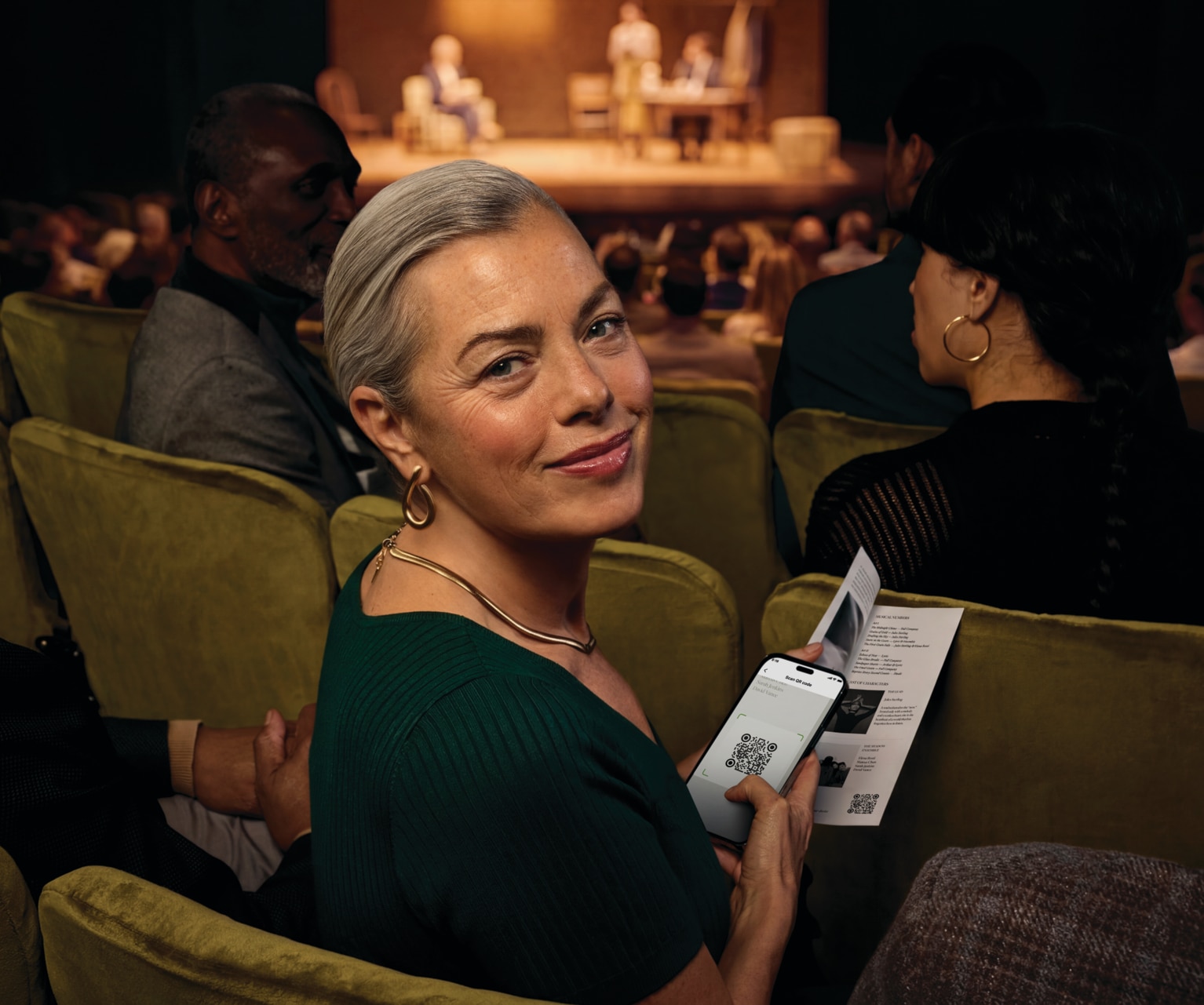 Person using Phonak Audéo™ EON   hearing aids in a theater with Auracast.