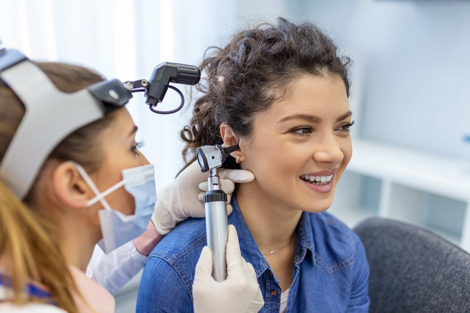 Hearing exam for a woman. Diagnosis of impairment and hearing testing in adults. Patient woman during an ear check-up with an audiologist; Shutterstock ID 2129830616; purchase_order: -; job: -; client: -; other: -