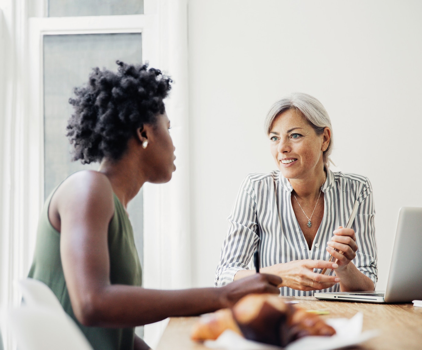 Two women having a discussion at a conference table