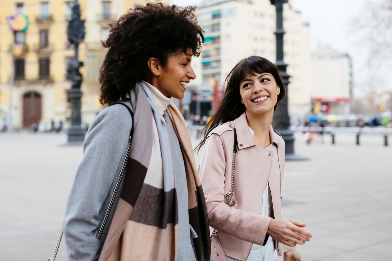 Two women talking and walking
