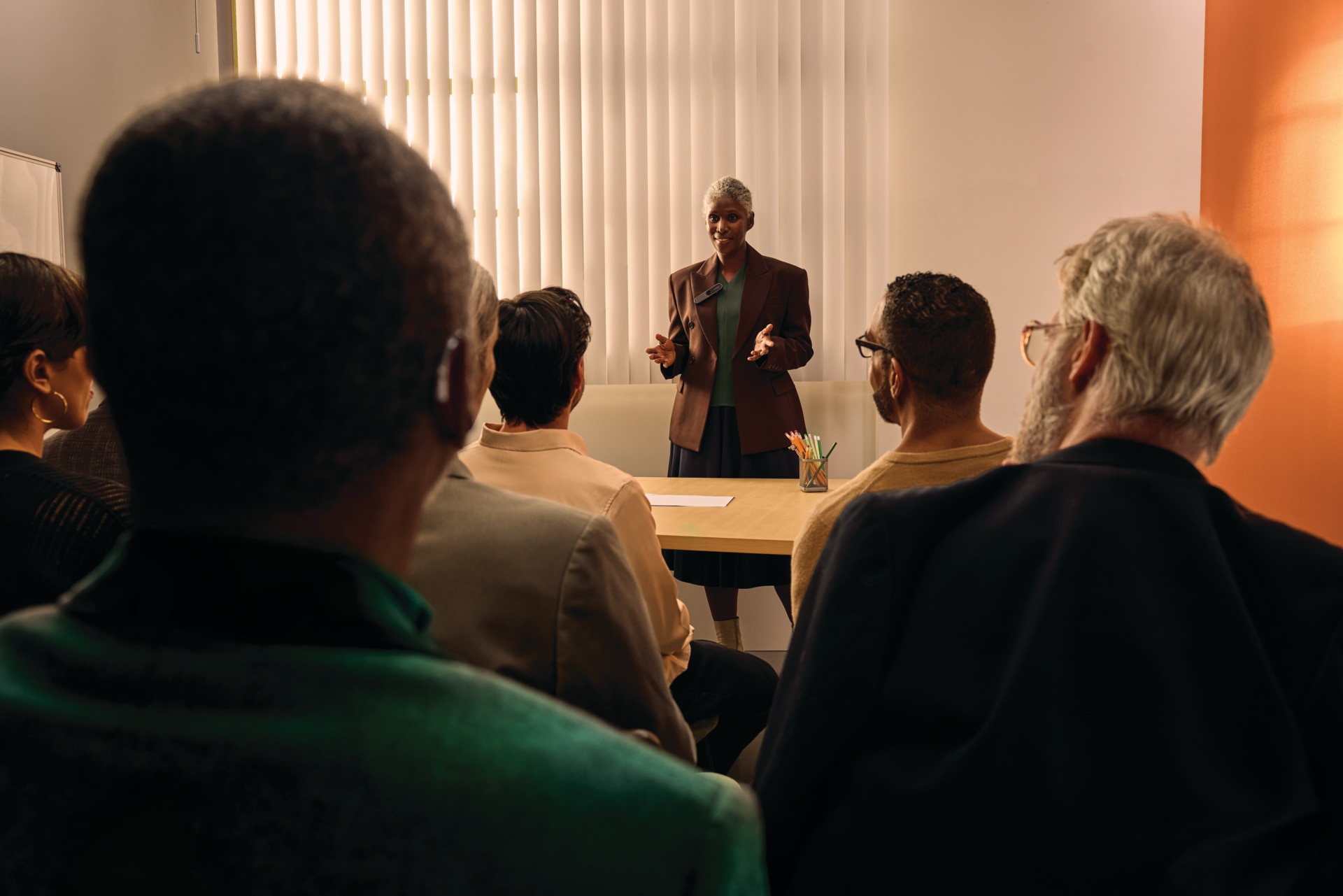 A group of people listening to a speaker during a meeting, presentation or training