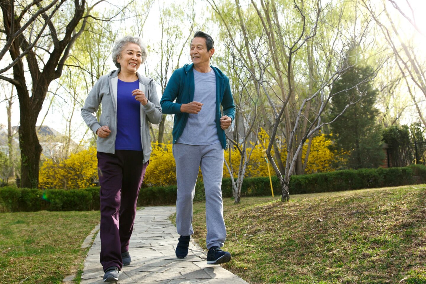 Senior couple jogging in a park during spring.
