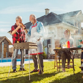 Elderly neighbors having backyard barbecue party