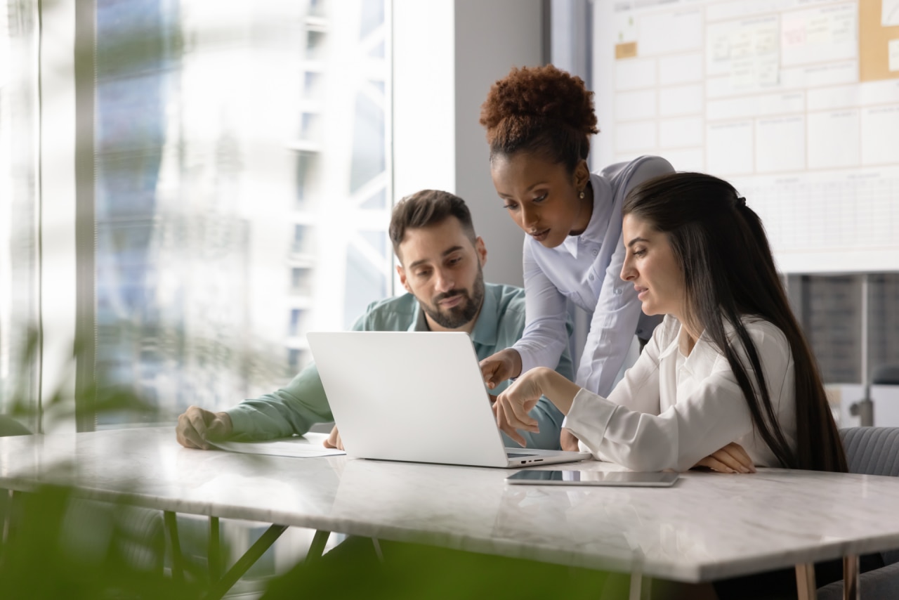 Diverse group of people working together on a laptop
