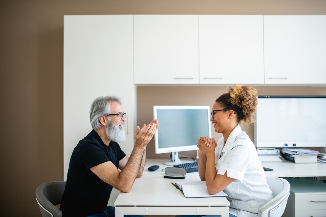 Mature man talking to a hearing healthcare provider