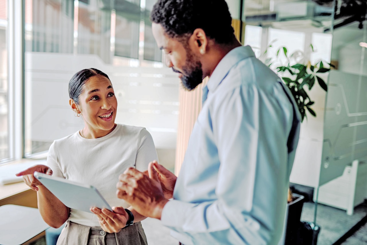 Woman holding tablet and talking with man