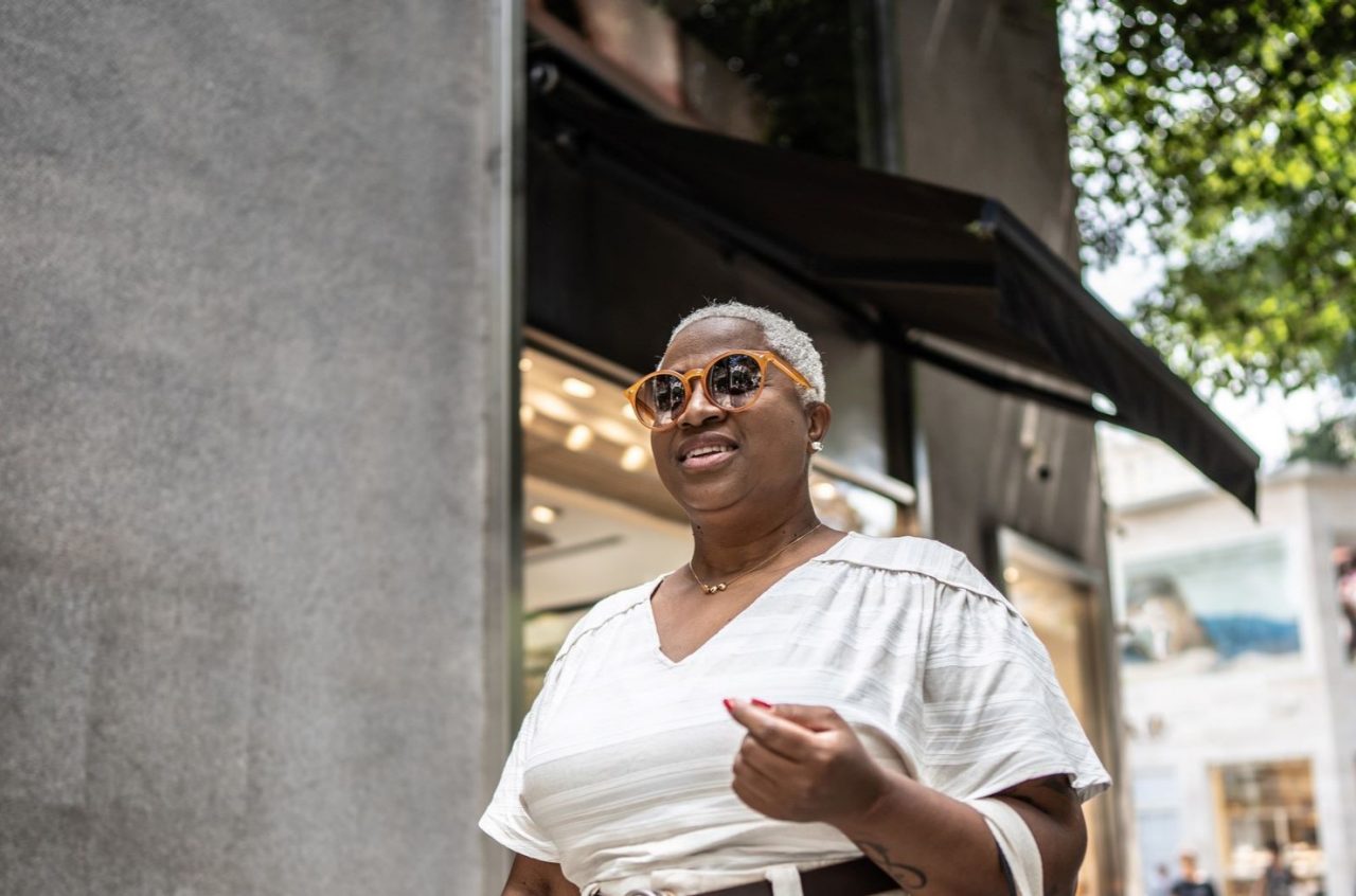 A woman walking down a sunny street