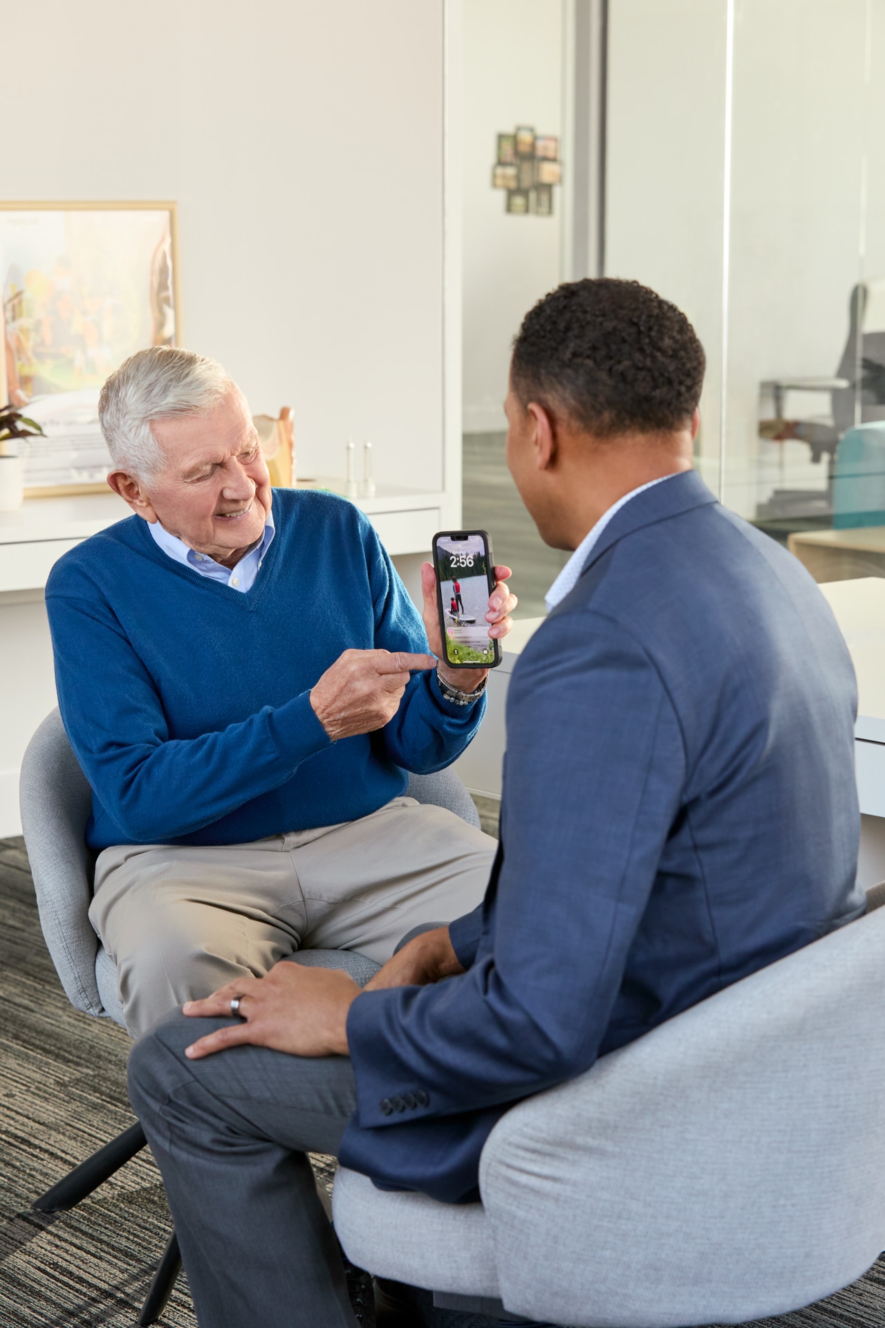 Businessman and older gentleman looking at cellphone
