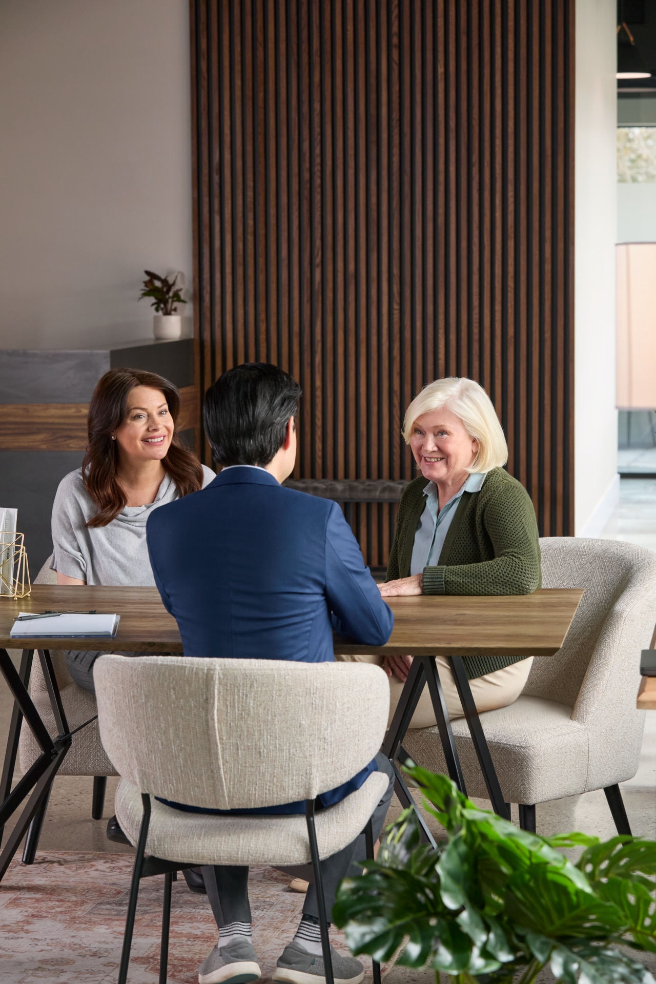 Man and two females sitting at a table talking