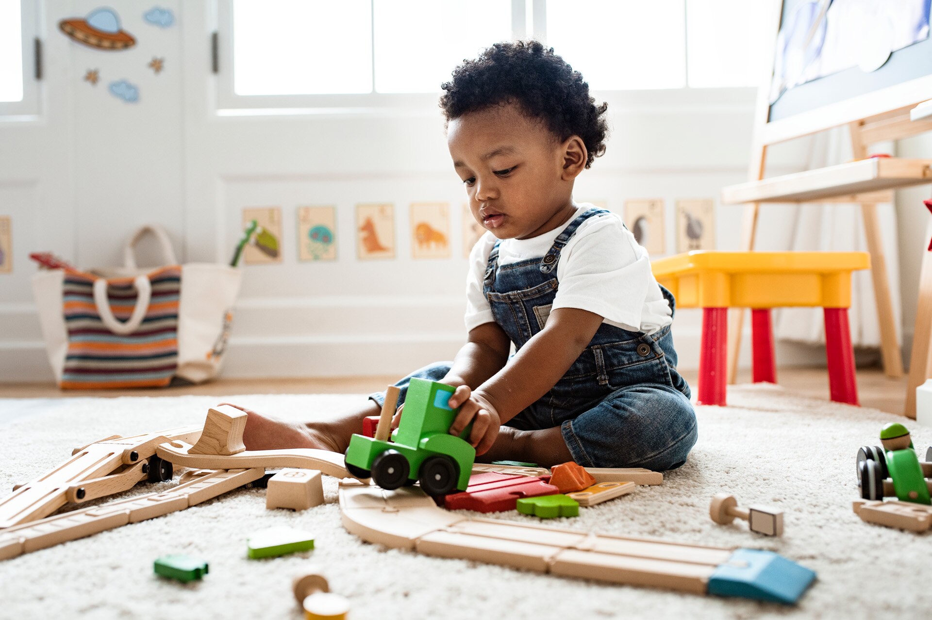 Cute little boy playing with a railroad train toy; Shutterstock ID 1248242851; purchase_order: -; job: -; client: -; other: -