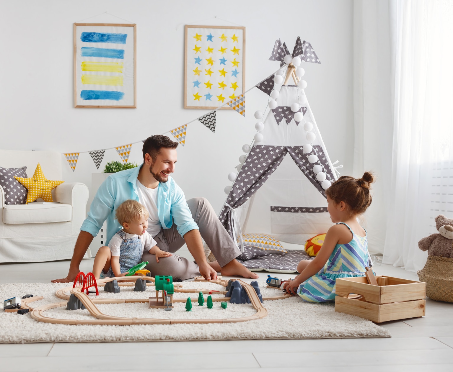 family father and children play a toy railway in the playroom
; Shutterstock ID 1033143271; purchase_order: -; job: -; client: -; other: -